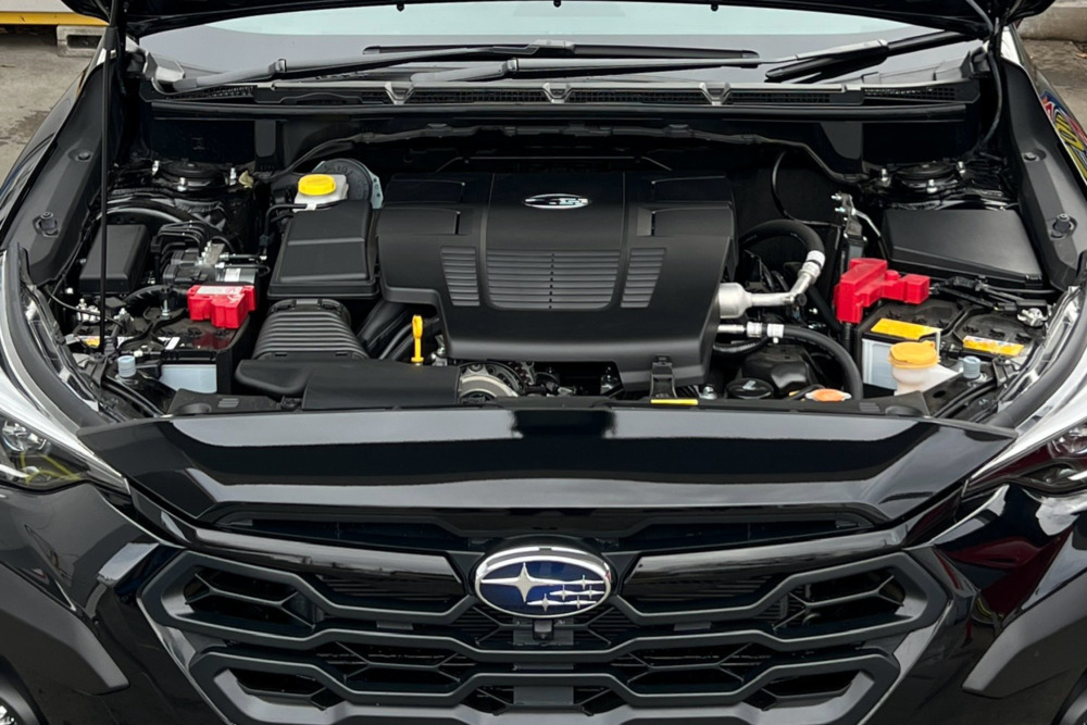 クロストレックのエンジンルーム。エンジンのほか、補器類でぎっしり詰まっている。この車の場合バッテリーが左右に２機搭載されていて、さらにスペースの余裕がない。