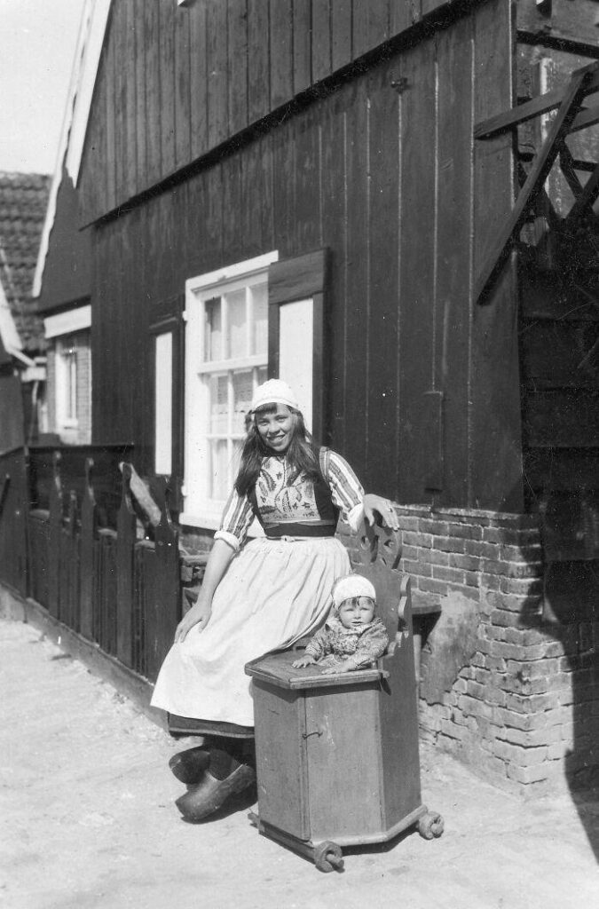 1929年、オランダの木製乳母車で赤ちゃんと一緒に若いオランダの母親。