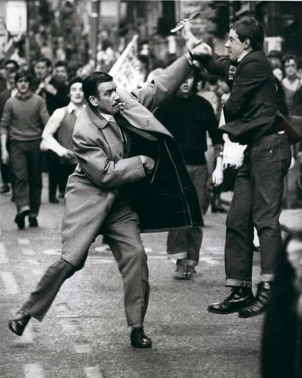 プレーンクロスの警官は、1971年にグラスゴーでかみそりの攻撃をブロックします（アイルランドの連帯のための3月中）。