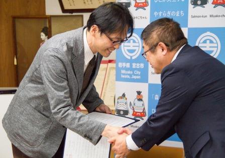 後藤康樹副院長と山本正徳 宮古市長がお辞儀をしながら握手をしている写真