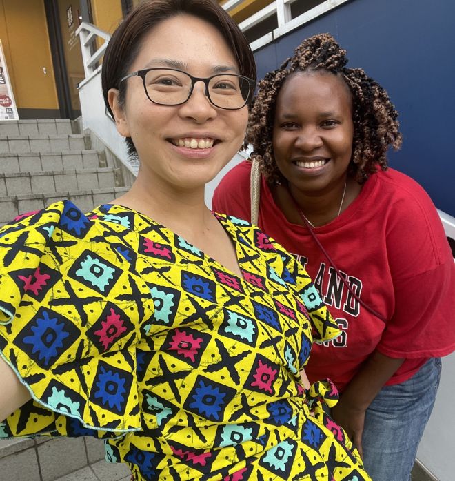 東アフリカの布「キテンゲ」の服。色や模様にプライドや願いが込められていると言い、着ると勇気が湧いてくるような気がした（写真はウペンドさんと筆者）