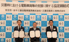 男性3名が両手に締結書を持ち記念撮影をしている写真