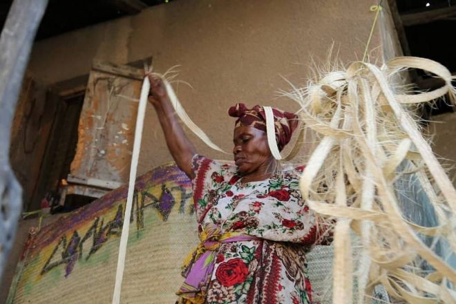 伝統的な技術で植物からマットを編む女性＝ウペンドさん提供