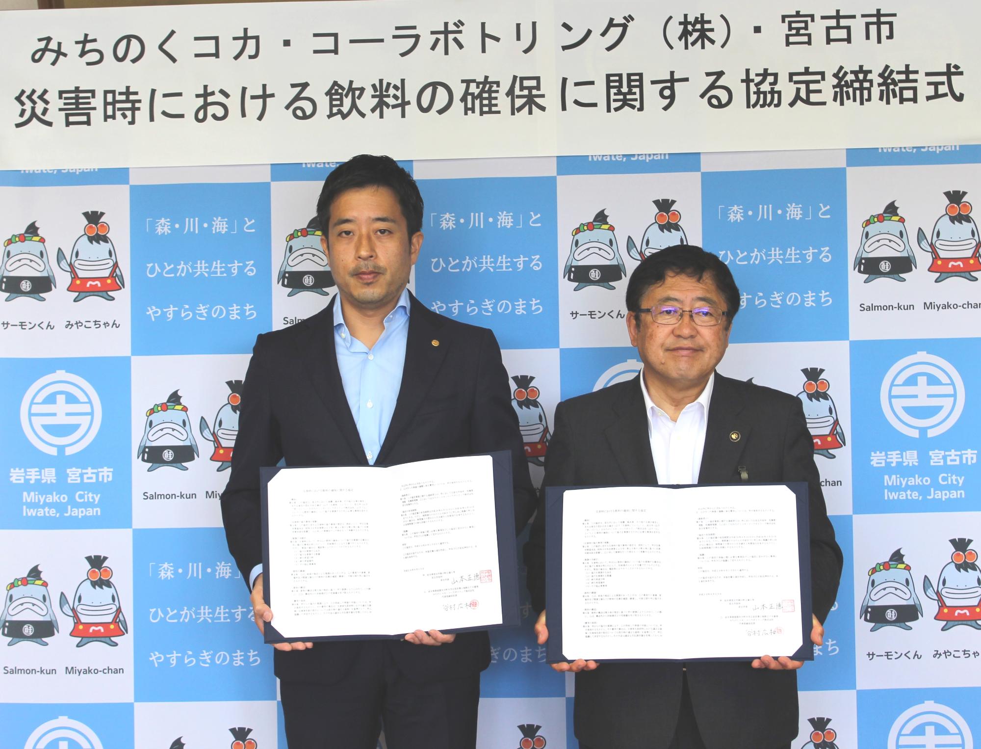 谷村広和社長と山本正徳 宮古市長が協定書を見せながら記念撮影をしている写真