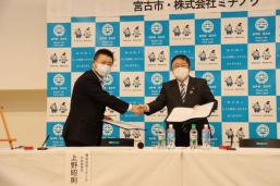 上野代表取締役と山本宮古市長が片手に締結書、右手で握手をしながら記念撮影をしている写真