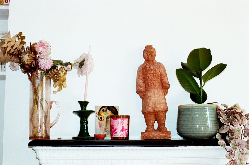 decorative mantel display featuring flowers plants and a statue decorative mantel display featuring flowers plants and a statue