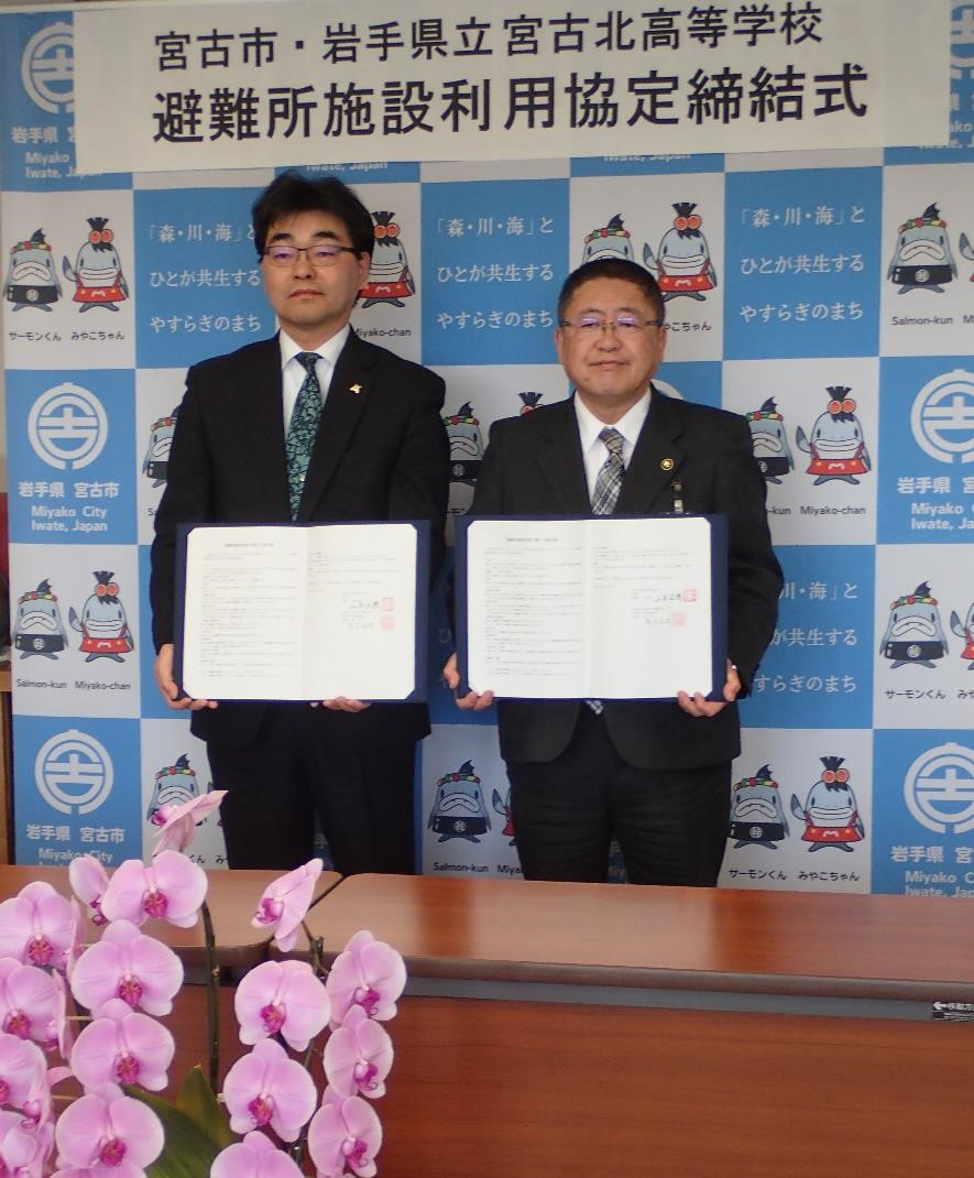 熊谷和浩校長と山本正徳 宮古市長が並んで協定書を見せながら記念撮影をしている写真