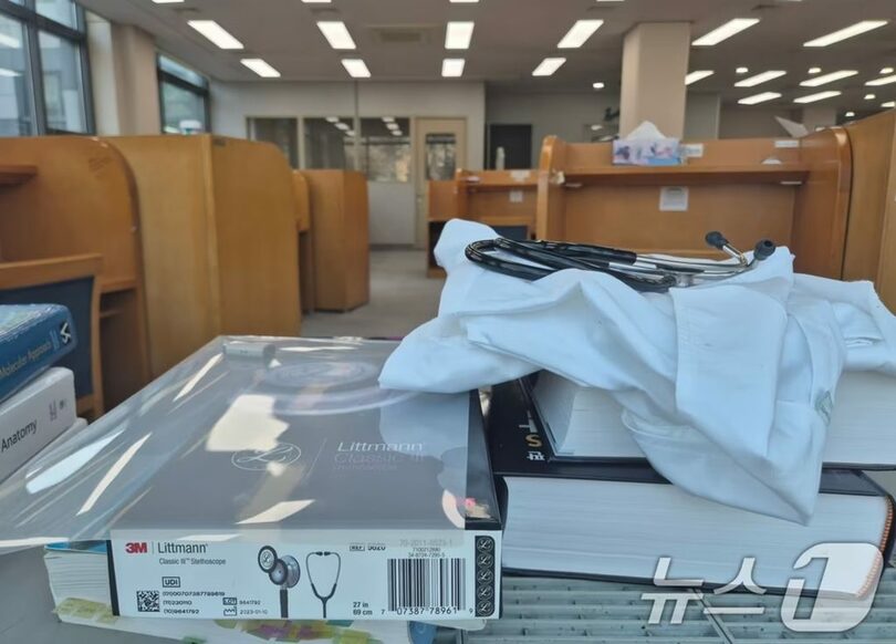 京畿道にある医科大学の図書館に置かれた専門書籍と白衣、聴診器(c)news1