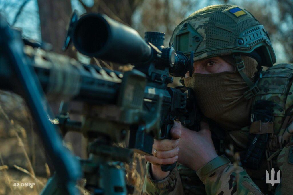 ウクライナ軍の第42回別々の機械化旅団から、彼のライフルの範囲を見ているウクライナ人の狙撃兵。