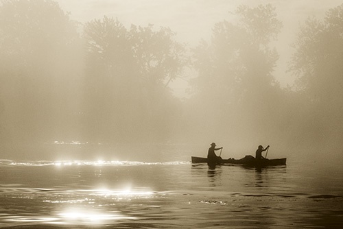柔らかな光のなか、ニューヨーク州プラッツバーグ近郊のシャンプレーン湖をカヌーが進む。一帯の先住民たちは何世紀も前から、こうした湖などの水域を交易や移動のために利用してきた。(PHOTOGRAPH BY AMY TOENSING)