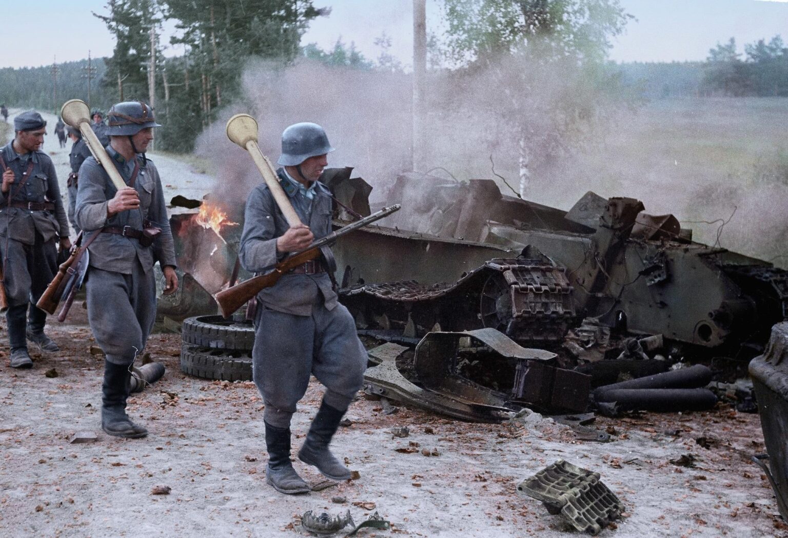 1944年半ばにタリハンタラのイマトラ道路で破壊されたT-34タンクをパンツァーファウストと一緒にパンツァーファウストを備えたフィンランドの反タンク部隊が通り過ぎる