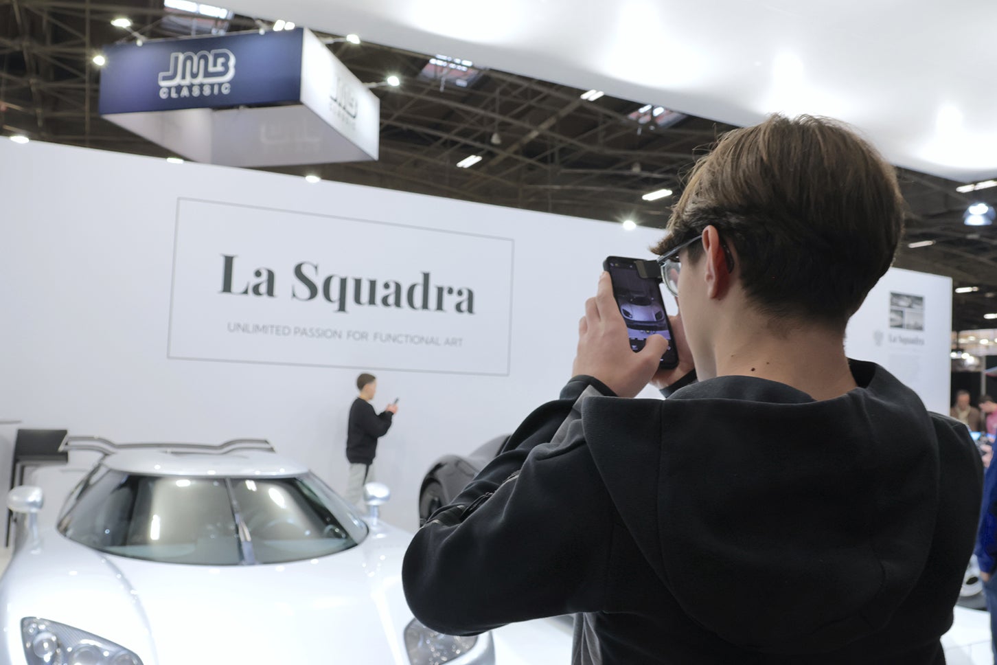 スーパーカー・スペシャリスト「ラ・スクアドラ」のブースで。「ケーニグセグCC850」にカメラに収める来場者。