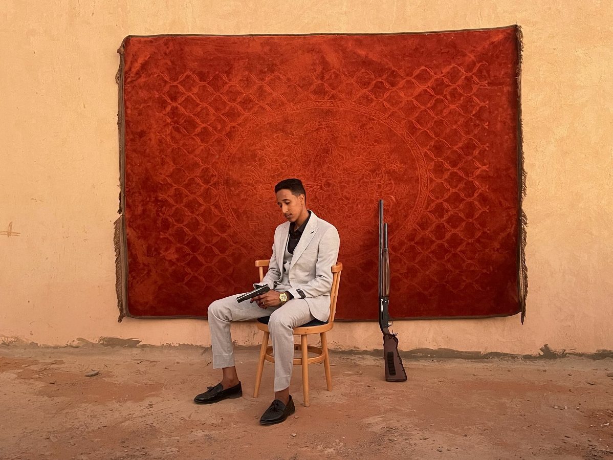 スーダン・オムドゥルマンで結婚式に臨む花婿。スーダンでは祝砲を撃って結婚を知らせるのが習慣になっている/Mosab Abushama/World Press Photo