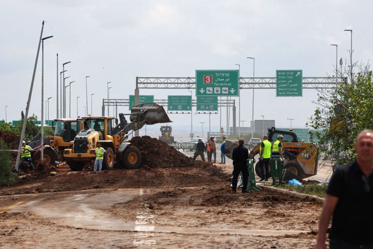 空港の近くの道路に散乱したがれきの撤去を行う作業員/Jack Guez/AFP/Getty Images