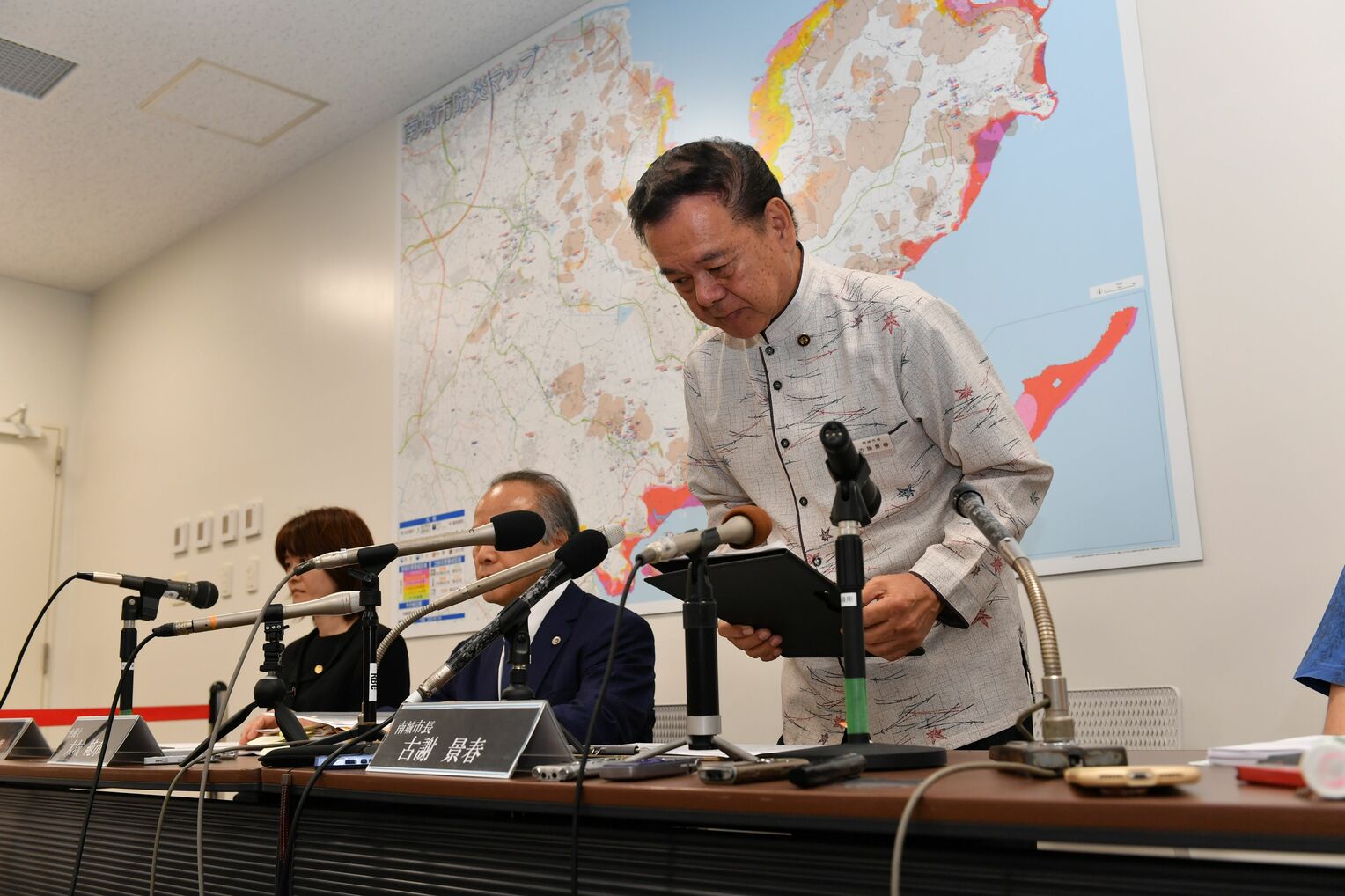 記者会見の冒頭で頭を下げる古謝景春南城市長＝28日午後