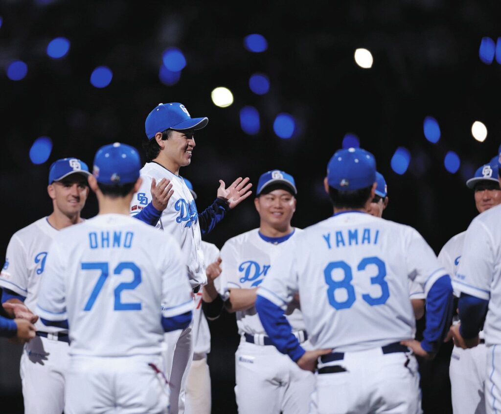 プロ初勝利を挙げ、輪の中心で一本締めする三浦