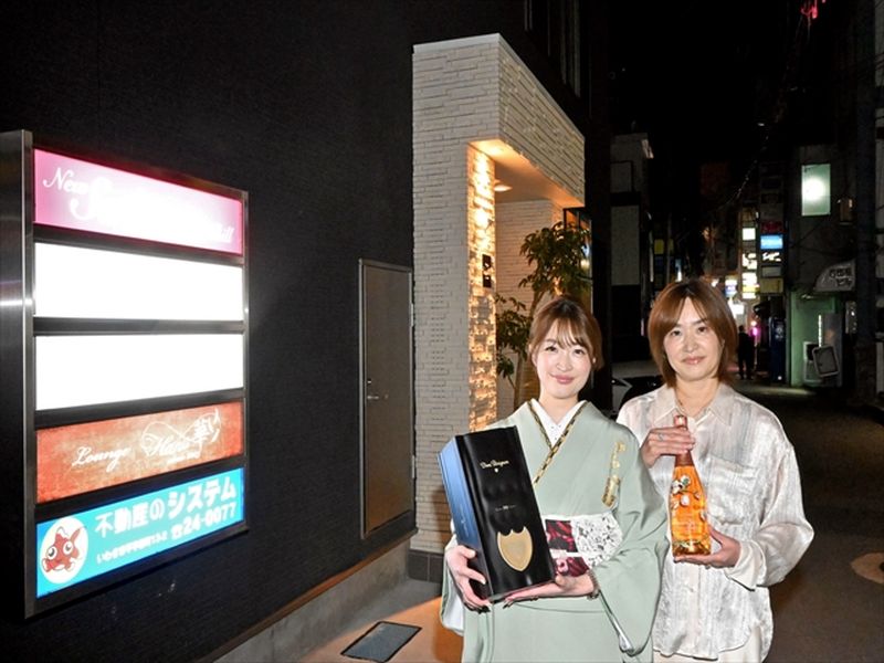 再建されたビルの前で、再出発に胸を膨らませる真理さん（右）と満弥さん