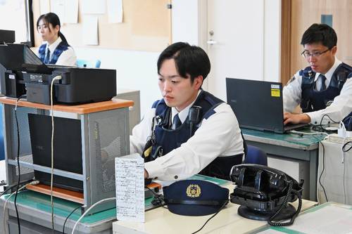 制帽を脱いで仕事に励む警察官＝１９日、青森市