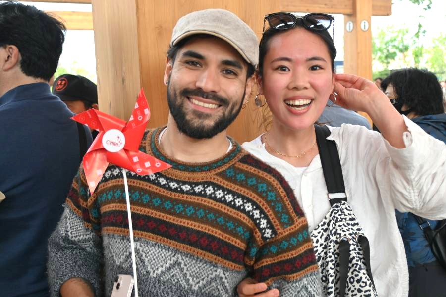 パレードを楽しんでいた来場者たち。日本在住のチリ人の男性が持つのは、ナショナルデーを記念し来場者に配られた風車（撮影5月12日：大阪・関西万博）