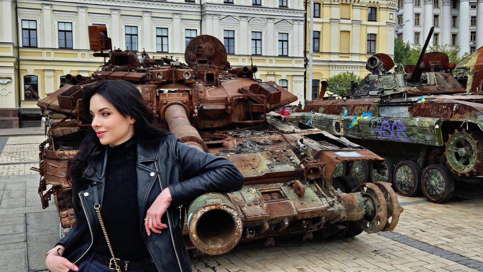 ウクライナの女性は、ロシアのT -90Aメインバトルタンク（MBT）とBMP歩兵戦闘車両（IFV）の燃え尽きた難破船でポーズをとっています。