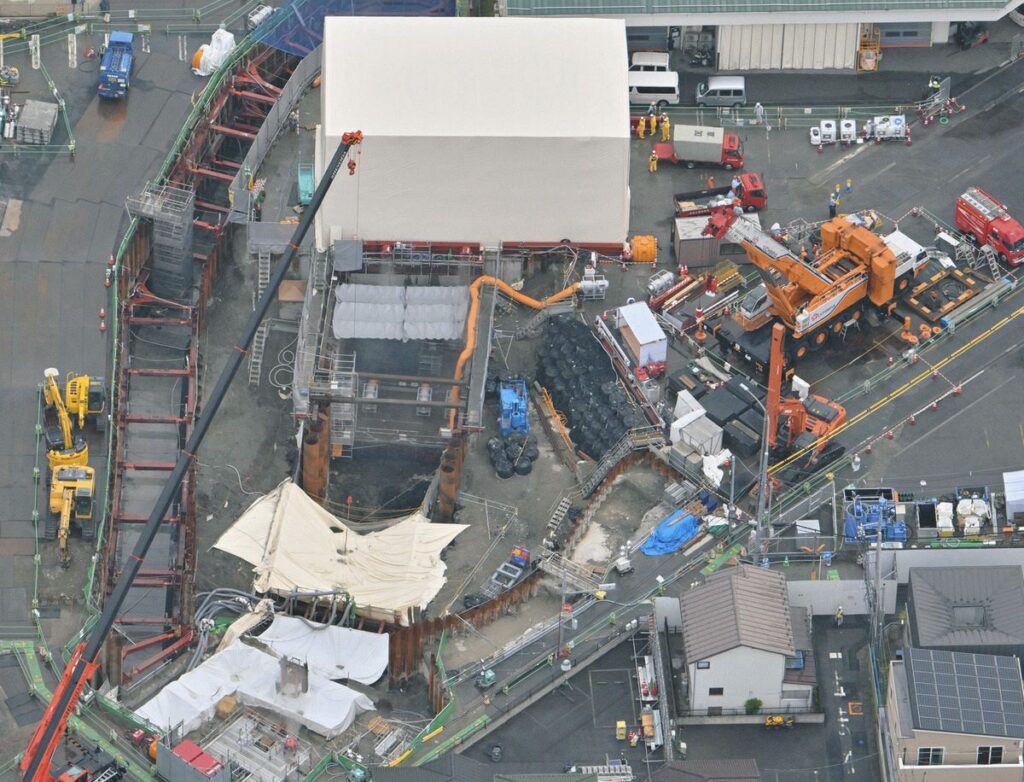 男性運転手とみられる遺体が発見された県道陥没事故の現場＝埼玉県八潮市で、本社ヘリ「あさづる」から（七森祐也撮影）