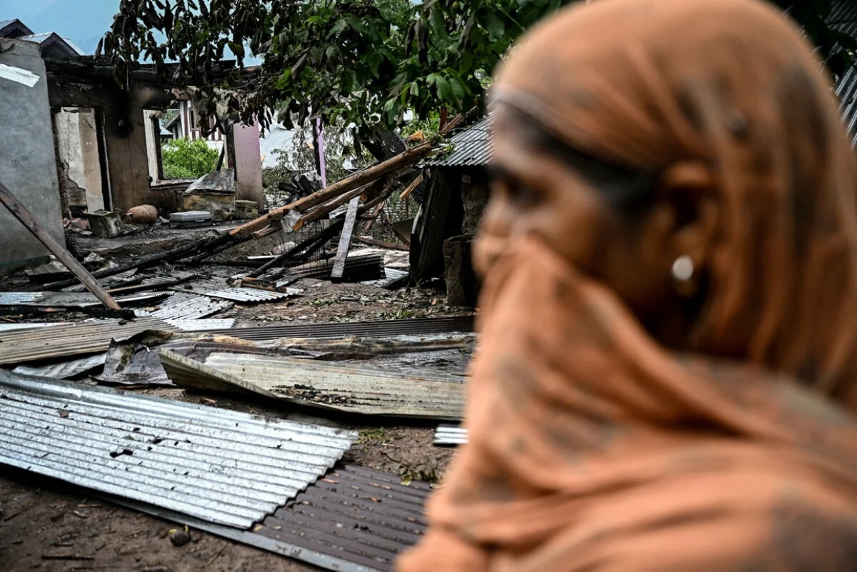 パキスタンの砲撃で破壊された民家の外に立つ女性＝８日、カシミール地方ウリのサラマバード村/Sajjad Hussain/AFP/Getty Images