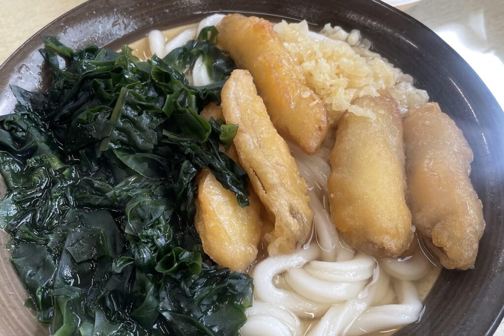 「牧のうどん」の魅力とは（ごぼう天うどんにわかめをトッピング）