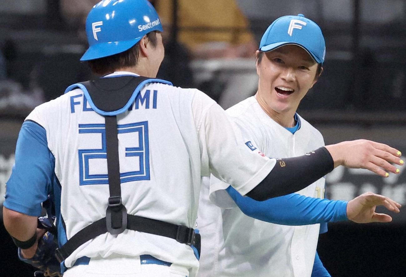 北海道移転1500勝を達成し、伏見と笑顔でタッチを交わす玉井