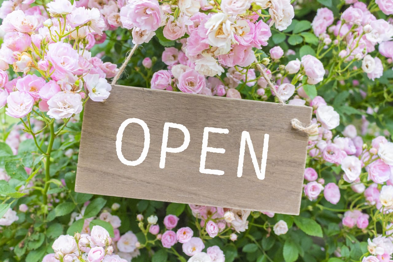 花に囲まれた「オープン」の札