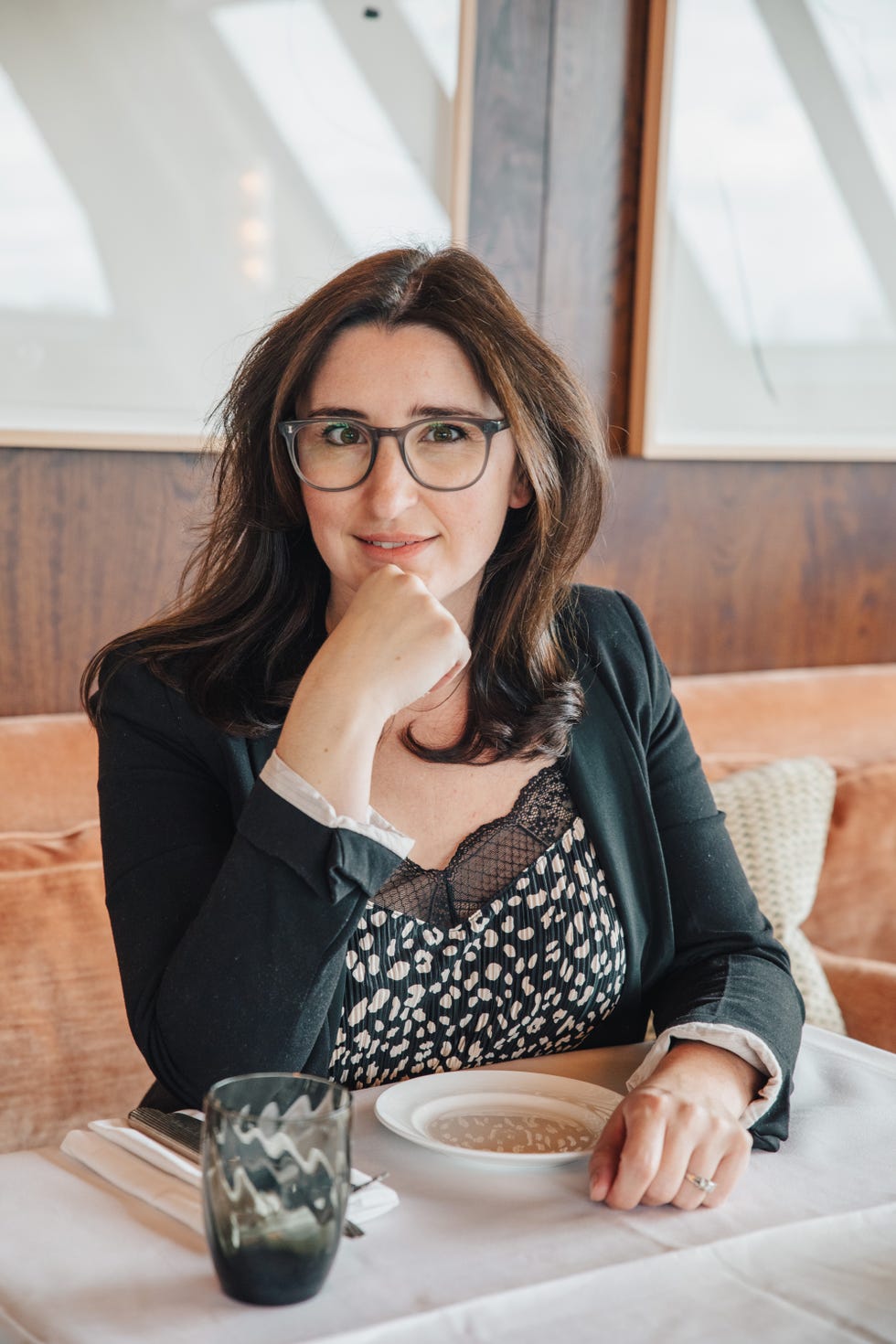 severine lammoglia sitting at a dining table with a plate and a glass