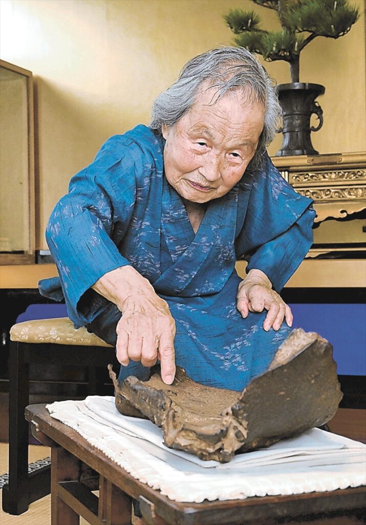 弟の命を奪った模擬原爆の破片をなで、「当たり前の死に方でなかった」と語る斎藤ミチさん＝７月１４日、福島市渡利の瑞龍寺（古川伊男撮影）