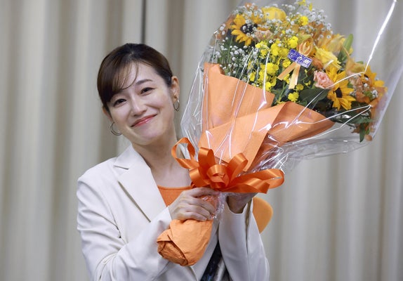 当選を確実とし、花束を手に笑顔を見せる参政党のさやさん（２０日午後８時５分、東京都千代田区で）＝冨田大介撮影