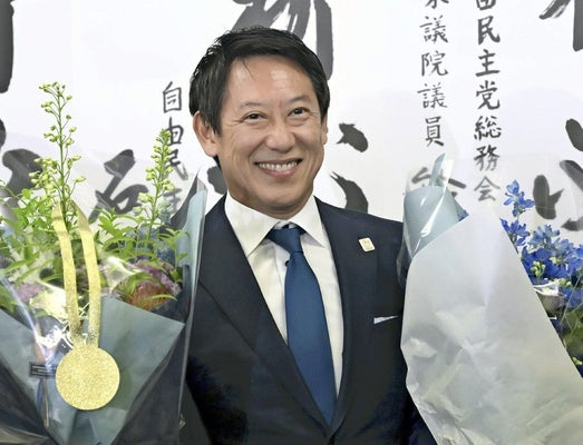 当選確実となり、花束を手に笑顔を見せる鈴木さん（２０日午後８時２１分、新宿区で）