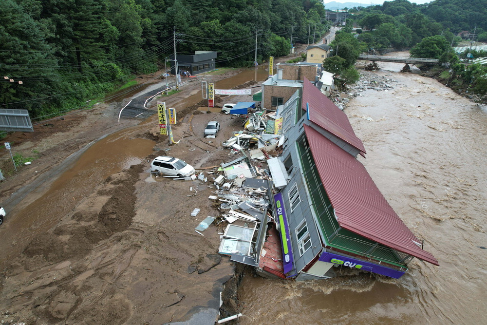 16日から5日間続いた集中豪雨で全国各地が水に浸かり麻痺した。 20日、中央災難安全対策本部（中対本）と消防当局によると、同日午後3時基準で全国で16人が死亡し、14人が行方不明になった。 被災者は1万3209人に達した。 人命被害は慶尚南道山清郡（キョンサンナムド&middot;サンチョングン）と京畿道加平郡（キョンギド&middot;カピョングン）に集中した。 山清郡では死者10人と行方不明者4人が発生した。 加平郡では2人が死亡し、8人が行方不明になったと集計された。 李在明（イ&middot;ジェミョン）大統領は同日、「大きな被害を受けた地域を特別災難地域に早期に宣布する案を推進せよ」と指示した。 写真は同日、京畿道加平郡鳥宗面（キョンギド&middot;カピョングン&middot;チョジョンミョン）で1時間当たり76ミリの大雨が降り、コンビニの建物が河川沿いに崩れ落ちた様子。 加平（カピョン）ハン&middot;ジュヒョン記者