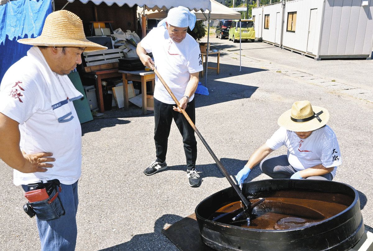 漆をかき回す職人を見守る八井貴啓社長（左）＝輪島市横地町で
