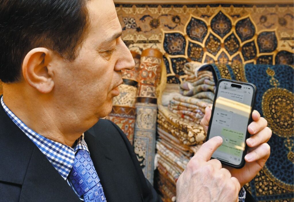 イランにいる弟とのやり取りを見るアリさん＝東京都武蔵野市で（一部画像処理）