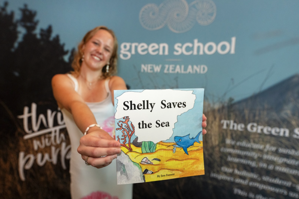 絵本と共に映る卒業生Jess｜Image via Green School NZ
