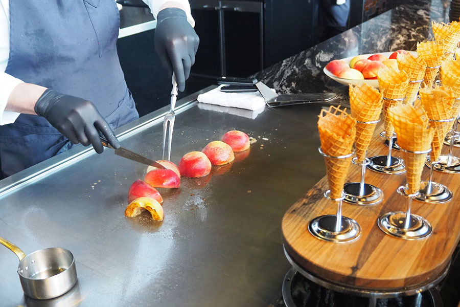 ライブキッチンコーナーでは、バターとともに桃に火を通し、さらにブランデーでフランベ