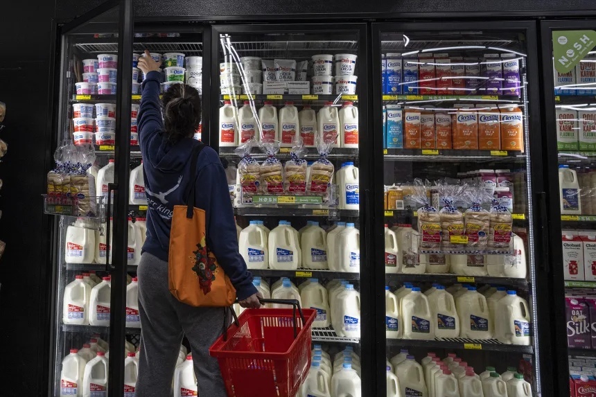 サンフランシスコの食料品店でカッテージチーズに手を伸ばす買い物客＝２０２２年５月/David Paul Morris/Bloomberg/Getty Images