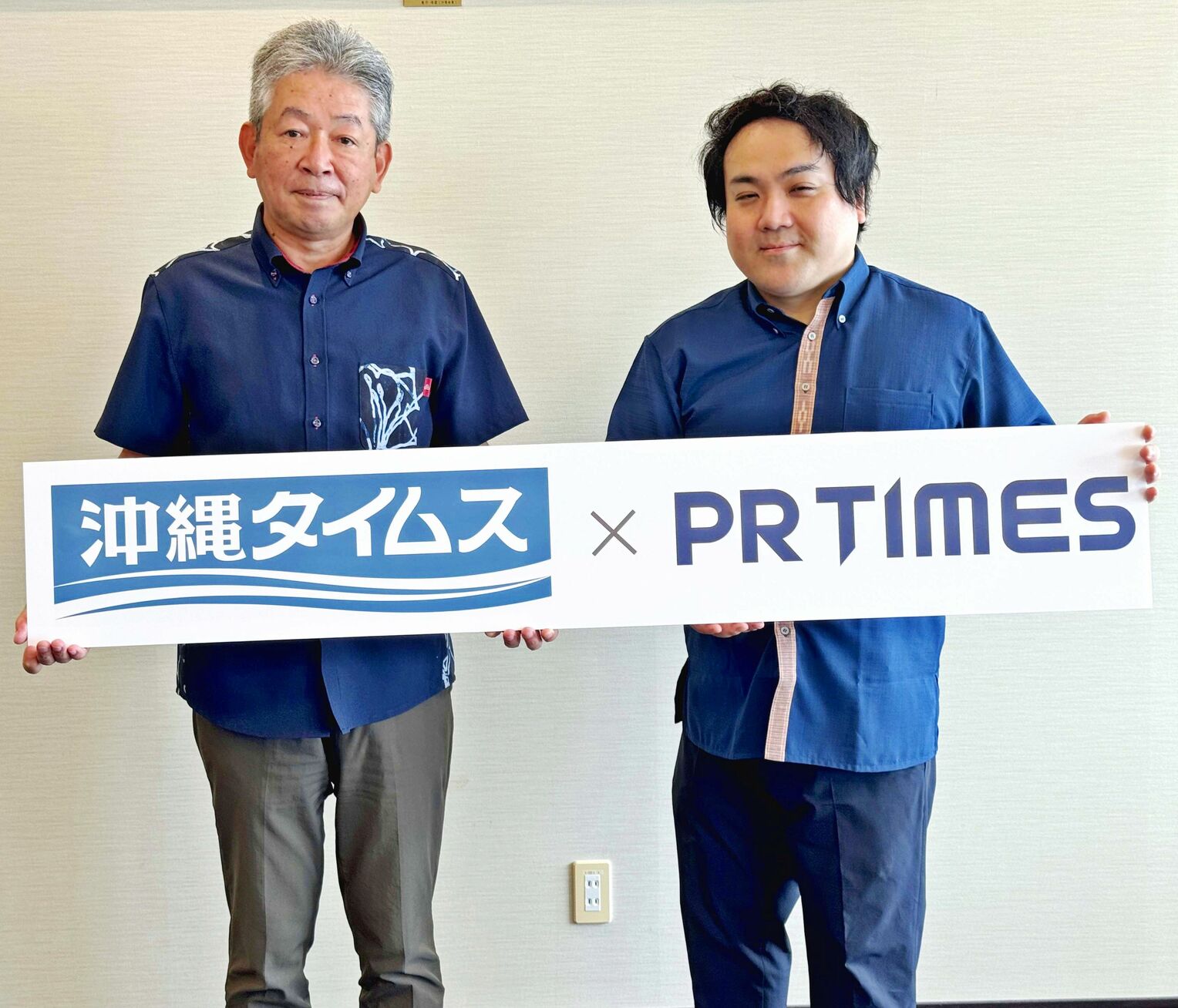包括業務提携契約を締結した（左から）沖縄タイムス社の比嘉敏幸常務とＰＲＴＩＭＥＳの高田育昌パートナービジネス開発室長＝１８日、那覇市・沖縄タイムス社