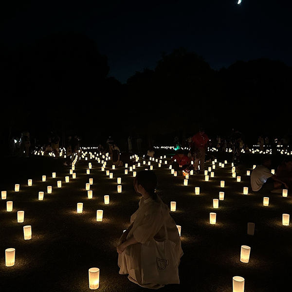 キャンドルに囲まれている人の後ろ姿