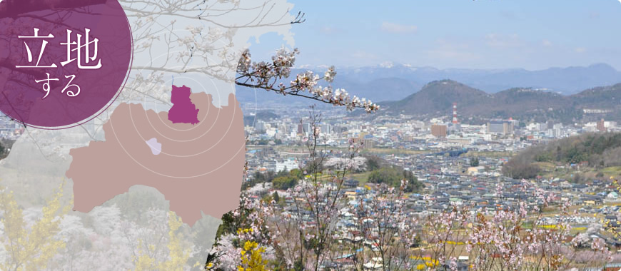 立地する（福島市の位置図とピンク色の花が咲いた高台から市街地を撮影した写真）
