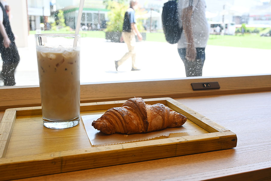 カウンター席にはコンセントも完備。「濃縮カスタムミルクラテ」（600円）、「国産発酵バターのクロワッサン」（291円～）などパン類も