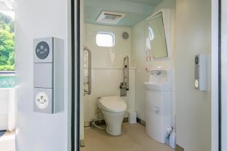 手すりなどが設けられた宮古うみねこ丸の船内のトイレを前方から写した写真