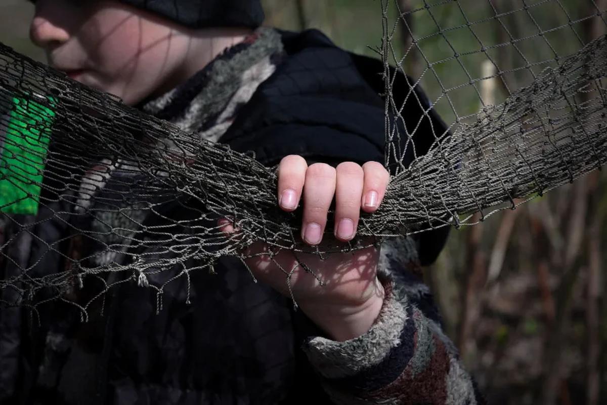 即席の対ドローン用ネットを手にする６歳の少年＝４月、ウクライナ・ハルキウ州/Violeta Santos Moura/Reuters
