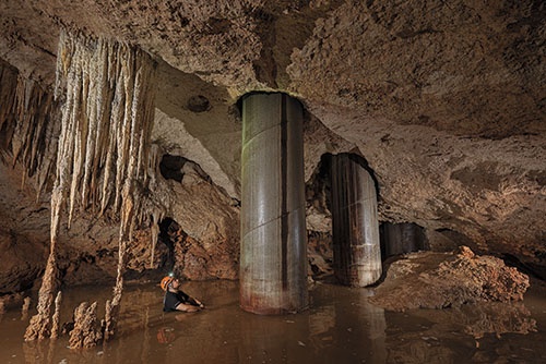 生物学者のロベルト・ロホが入っているのは、プラヤ・デル・カルメンの南に位置する洞窟群のセノーテ。ここの水は澄み切っていたが、鋼鉄の柱を地下に打ち込む際に流出した液体によって、濁ってしまい、帯水層も汚染された。（PHOTOGRAPH BY ROBBIE SHONE）