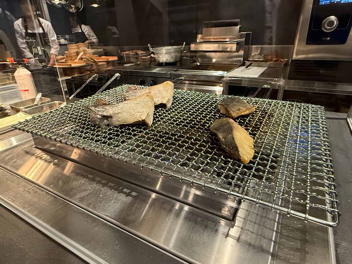 主菜の焼き魚は、目の前のオープンキッチンで一枚ずつ丁寧に焼かれていて、立ちのぼる香ばしい香りに思わずお腹が鳴りそうになります。まさにライブ感たっぷり！