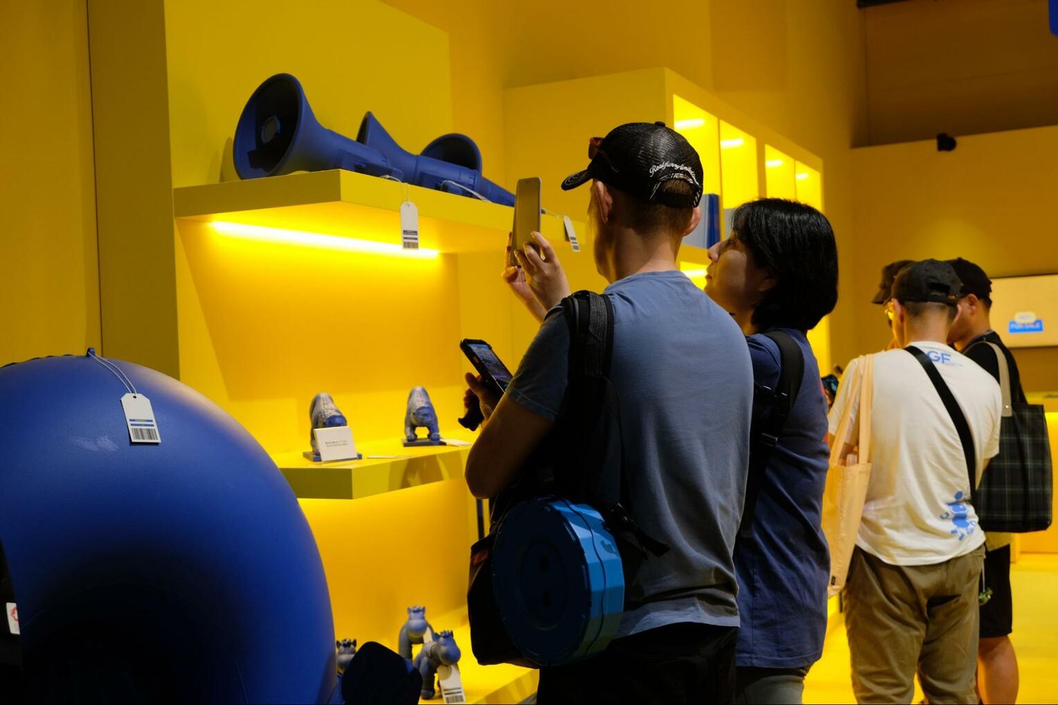 展示物のバーコードを読み込む来場者ら＝６月２１日、大阪市此花区の万博夢洲会場