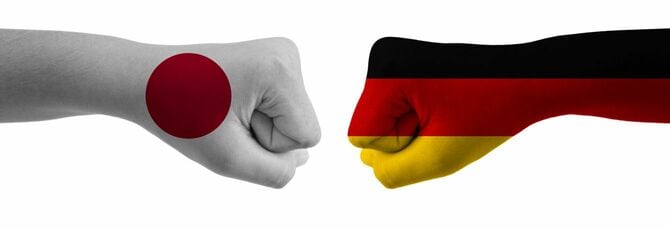 拳を突き合わせる日本の国旗が描かれた腕とドイツの国旗が描かれた腕