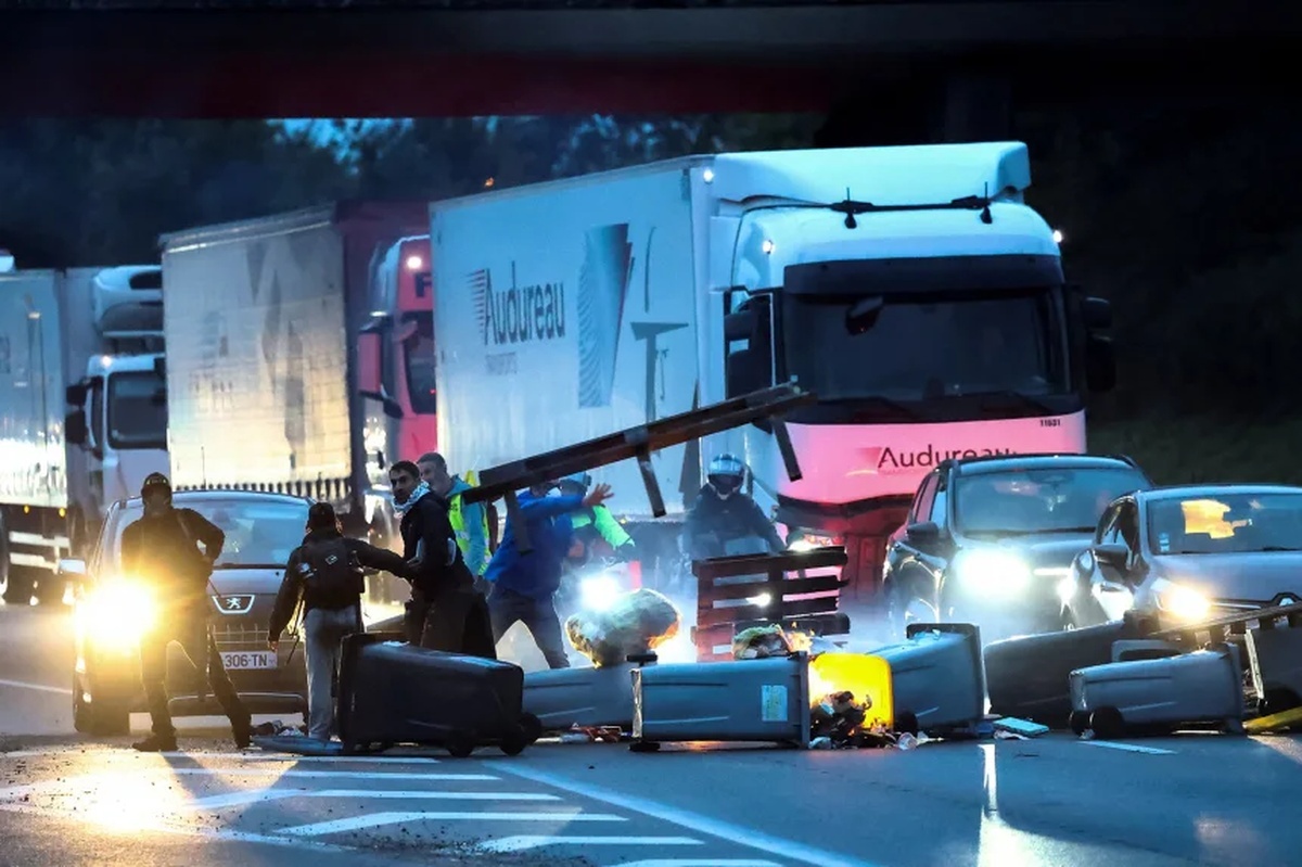 「全封鎖」の抗議活動の一環として、ごみ箱などで道路を封鎖するデモ参加者/Stephane Mahe/Reuters